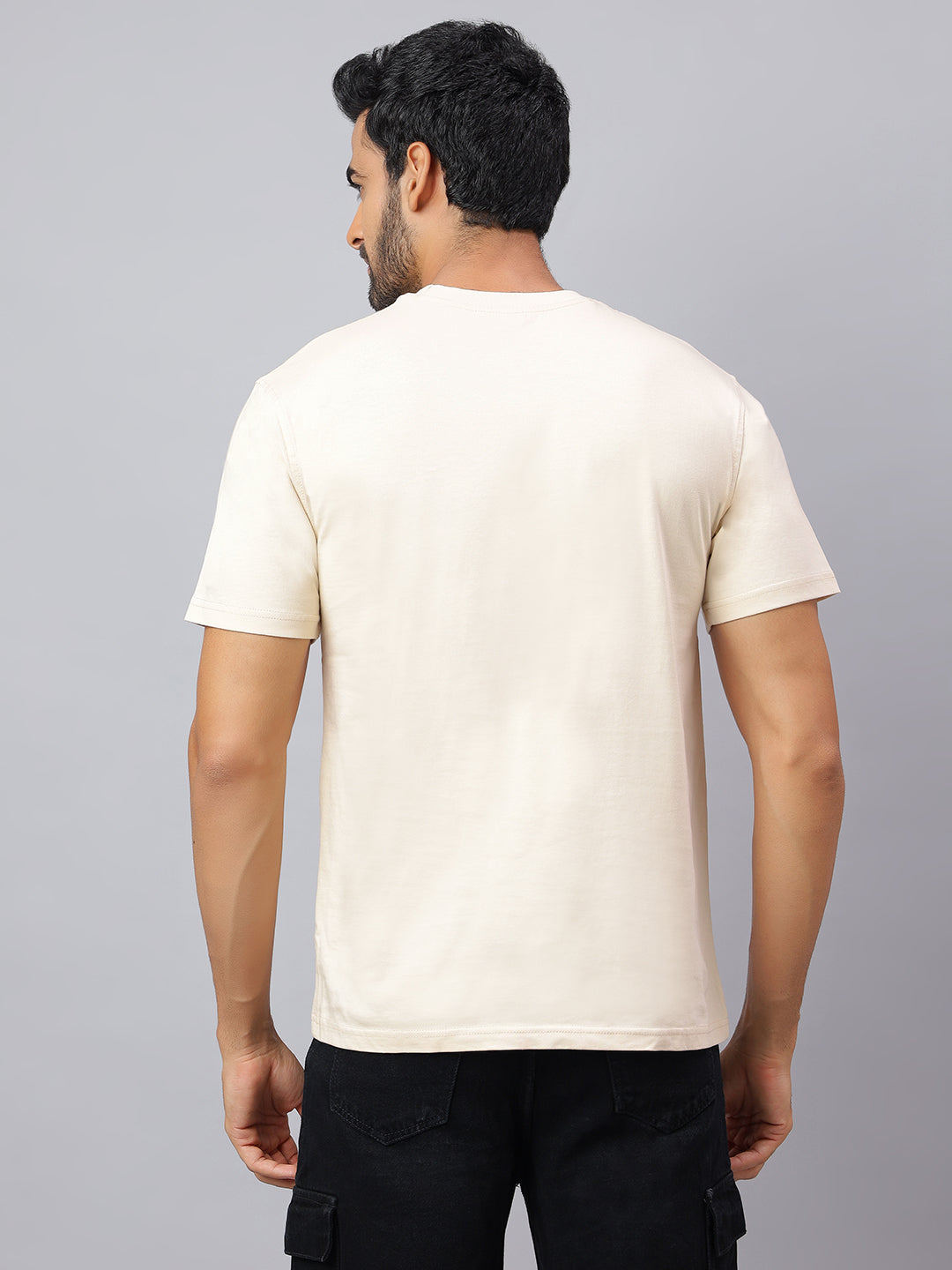 Man wearing a plain white t-shirt against a gray background