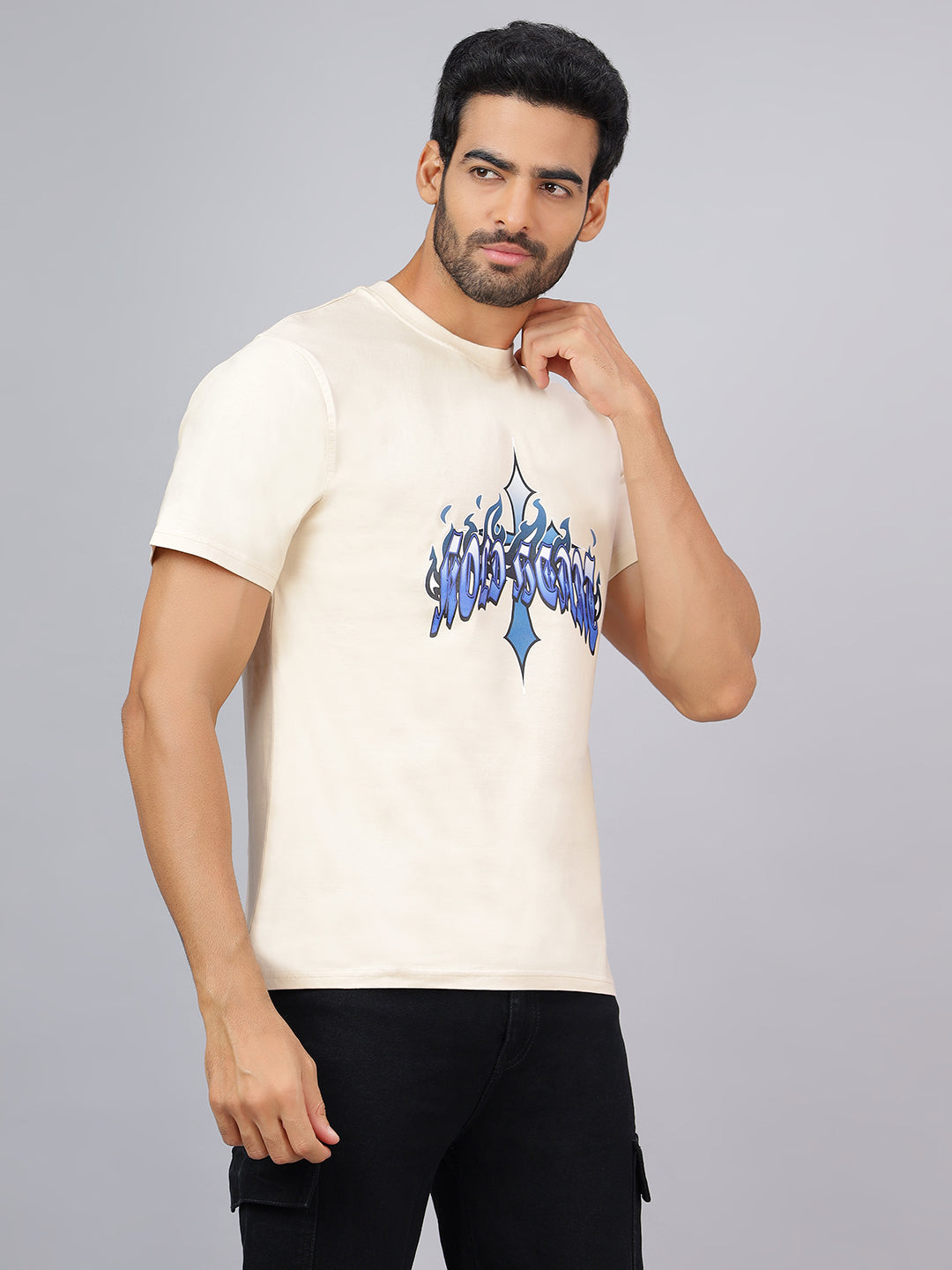 Man wearing a cream t-shirt with blue graphic design on a gray background