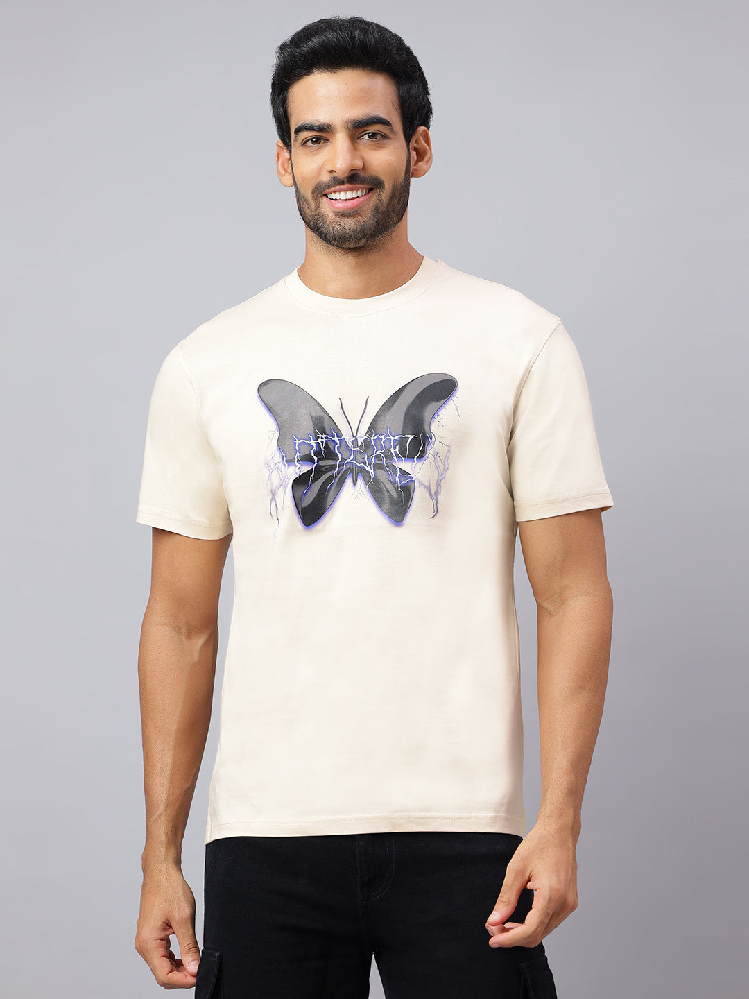 Man wearing a beige t-shirt with a butterfly design on a gray background