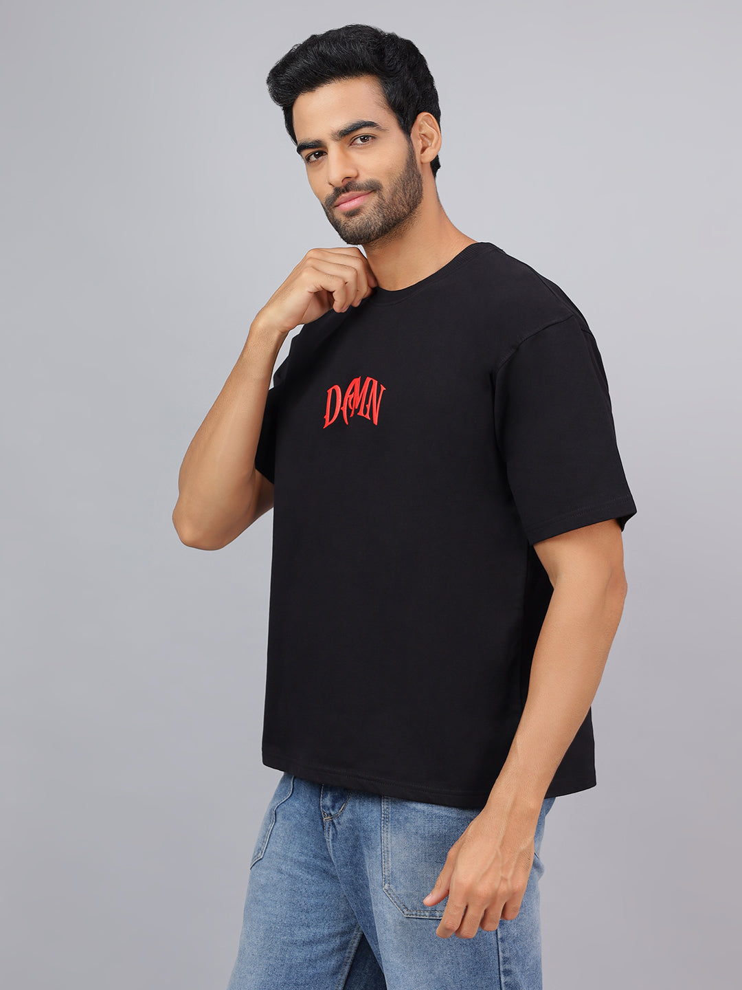 Man wearing a black t-shirt with red text on a gray background