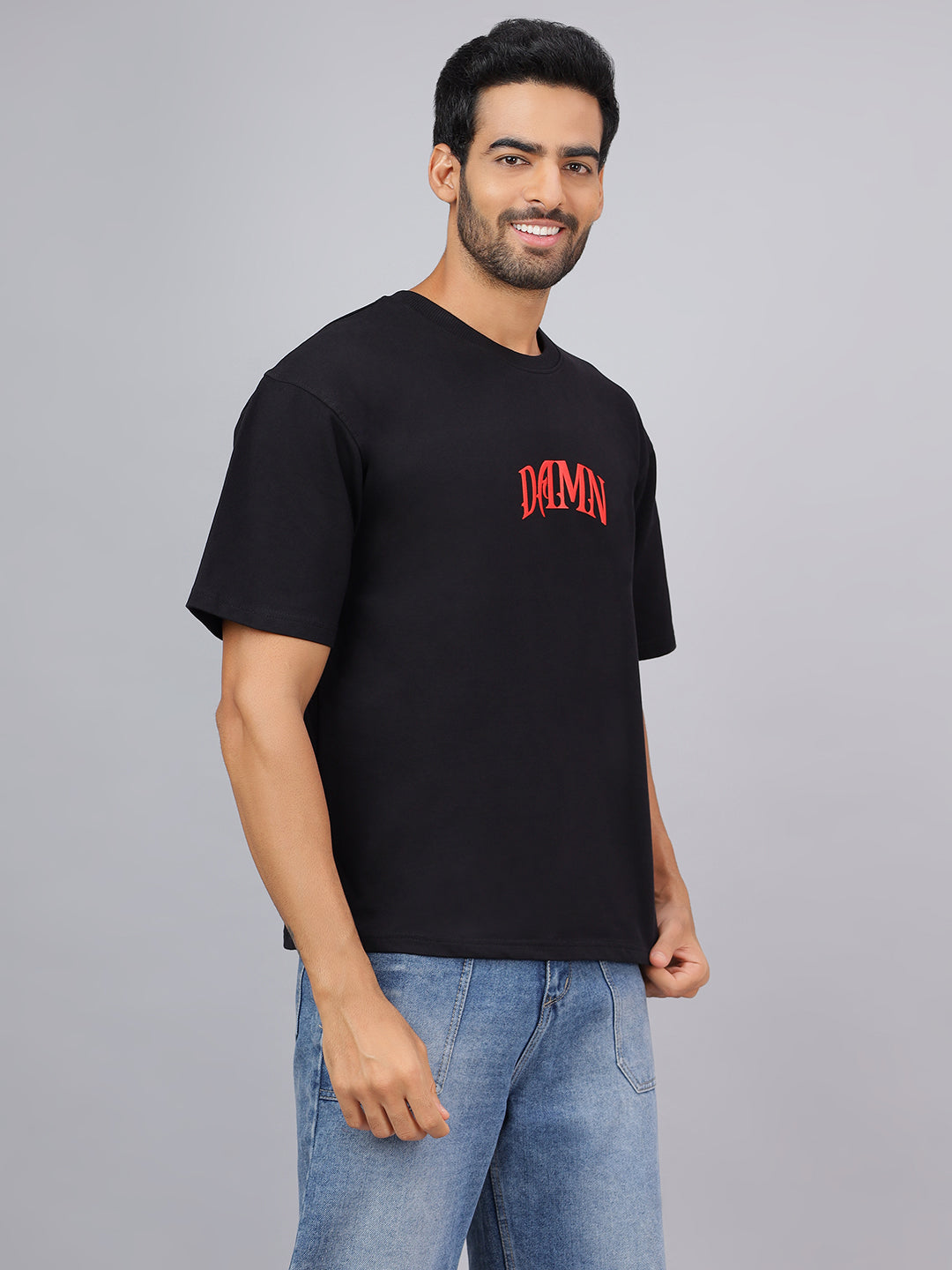 Man wearing a black t-shirt with red text on a gray background