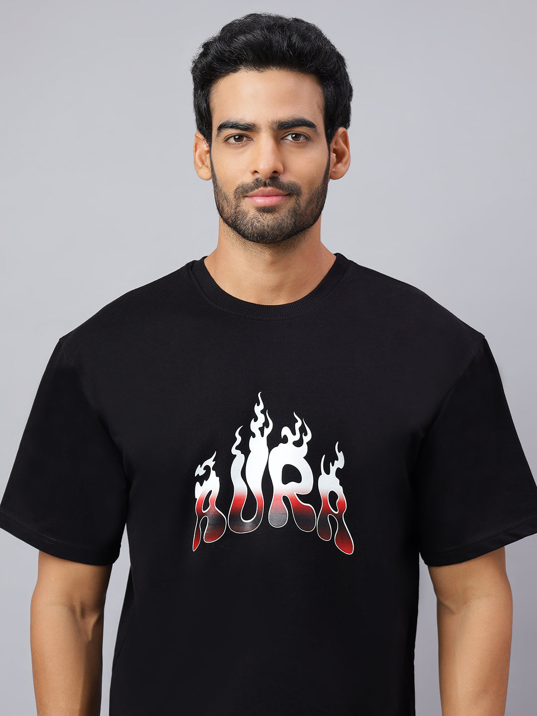 Man wearing a black t-shirt with a graphic design on a gray background