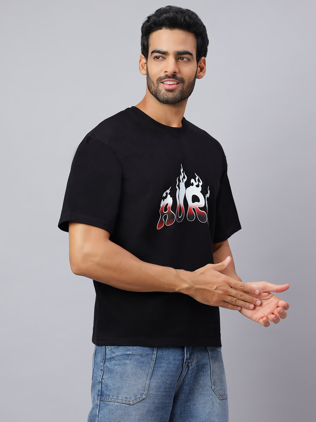Man wearing a black t-shirt with a graphic design on a gray background
