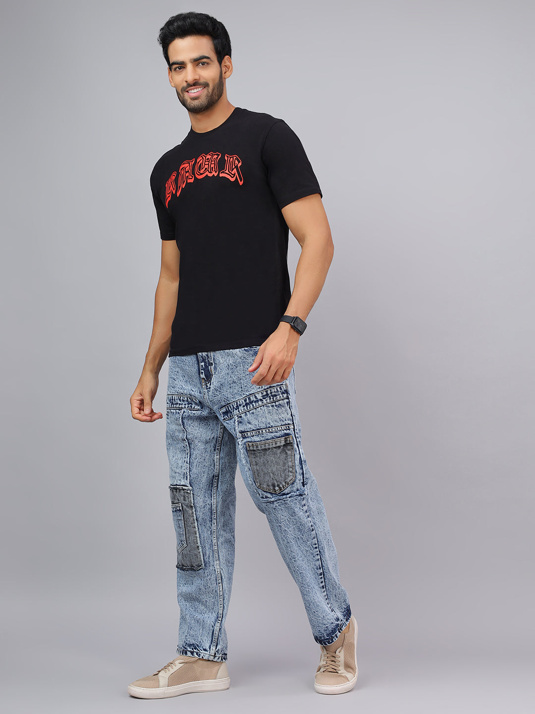 Man wearing a black t-shirt with red text and light blue jeans on a gray background