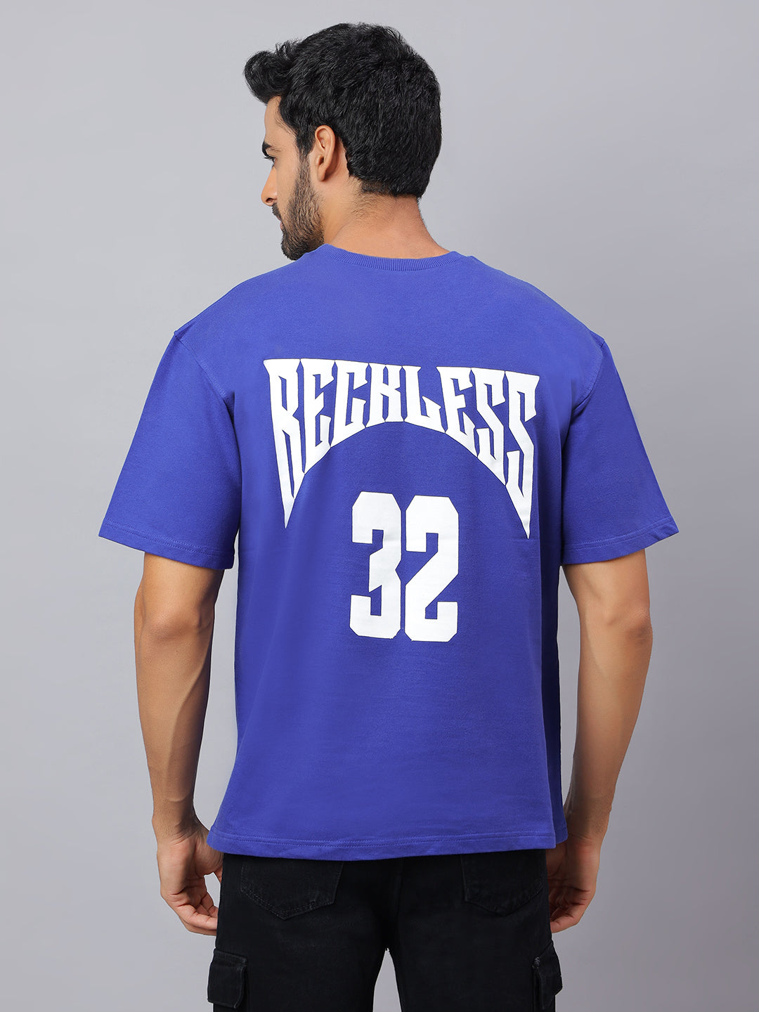 Man wearing a blue t-shirt with 'Beckless' and number '32' on the back against a gray background