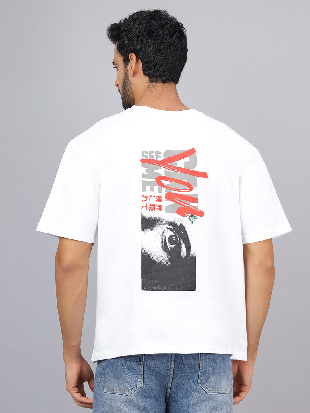 Person wearing a white t-shirt with a graphic design on the back against a gray background